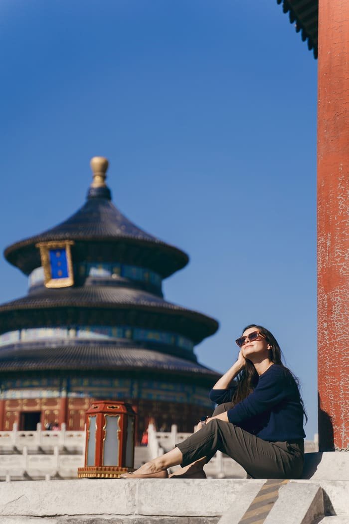 mujer con lentes oscuros posando frente a un monumento en Beijing